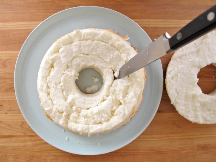 Cutting out a center ring of angel food cake.