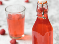 Raspberry Cordial in a glass bottle, showcasing vibrant red syrup