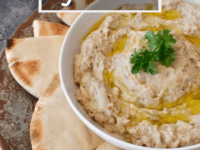 A bowl of classic Baba Ghanoush hummus with pita bread on the side