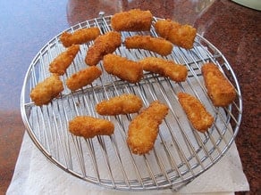 Fried fish draining on a rack.