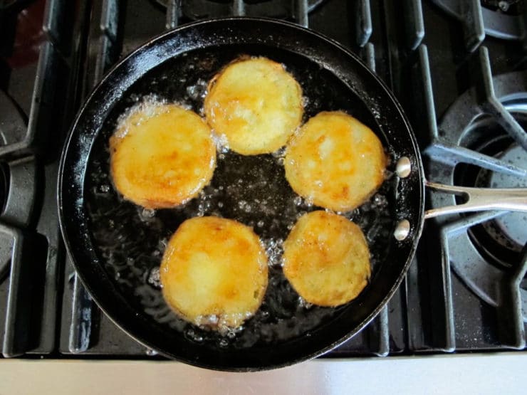 Frying green tomato slices in a skillet.