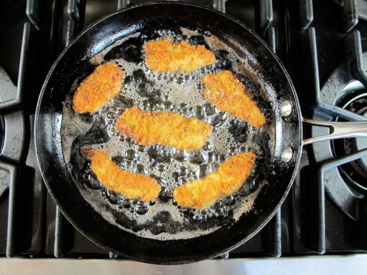 Frying chicken tenders in a skillet.