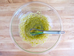 Combining lemon juice and pesto in a large bowl.