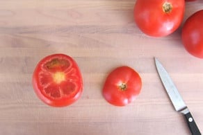 Slicing the tops off tomatoes.