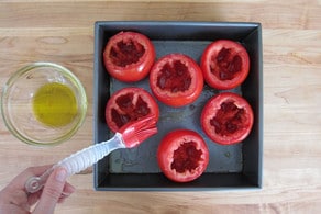 Cored tomatoes on a baking sheet.