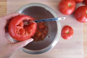 Scooping seeds out of tomatoes.