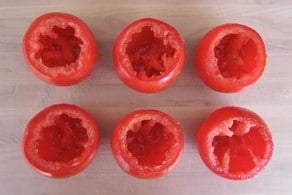Cored tomatoes on a cutting board.