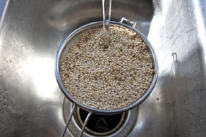 Rinsing quinoa in a strainer.