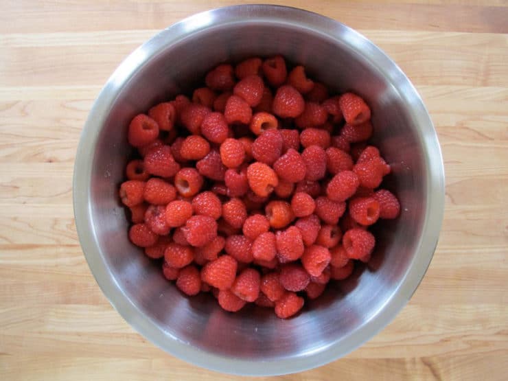 Rinsed raspberries in a large bowl.