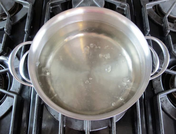 Dissolving sugar into a pot of boiling water.