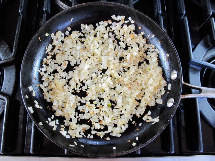 Frying diced onion in a skillet.