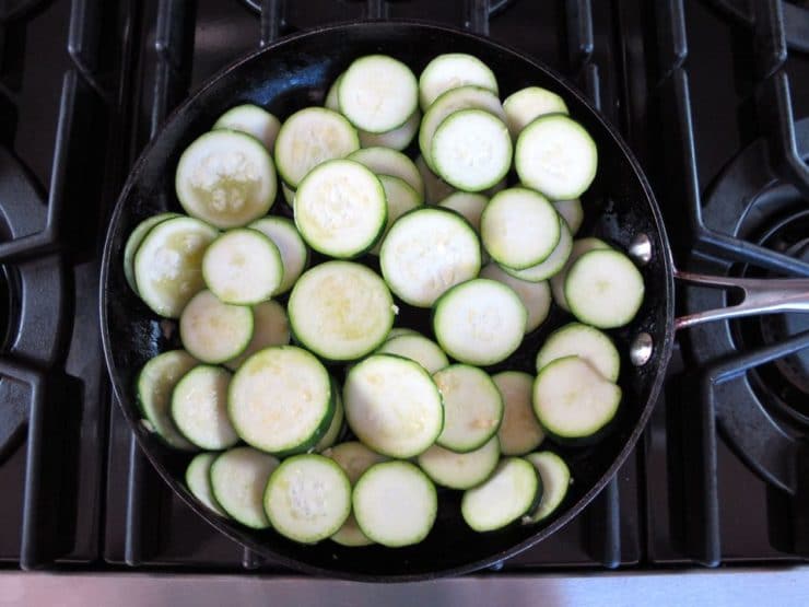 Zucchini rounds in a skillet.
