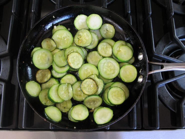 Zucchini rounds in a skillet.
