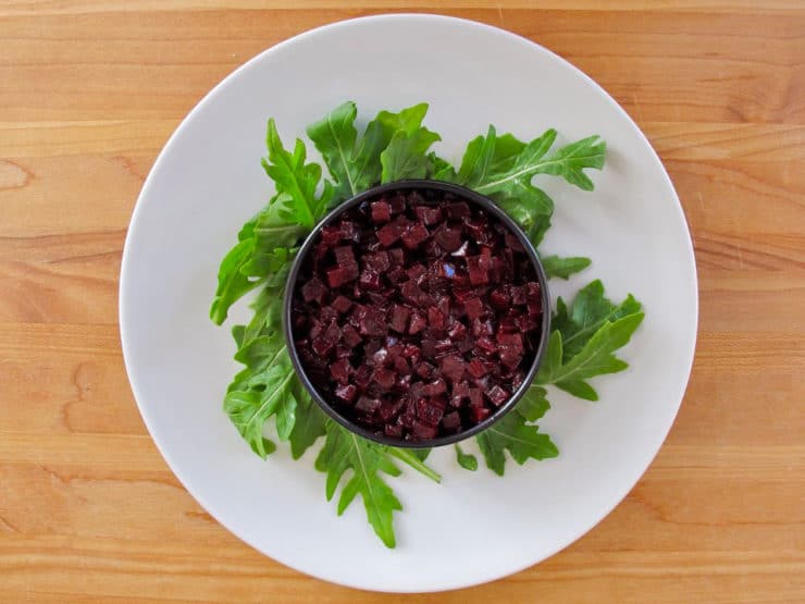 Beets in a circle mold on arugula.