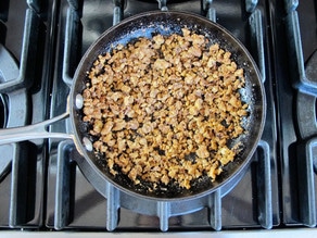 Adding seasoning to toasted, chopped nuts.