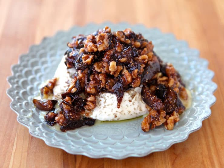 Figs and Cheese served in a blue plate on top of a wood table