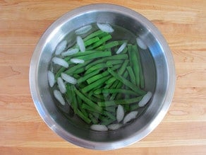 Shocking blanched green beans in ice water.