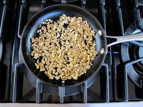 Dry toasting walnuts in a skillet.