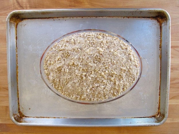 Blueberry crisp dish on a baking sheet.