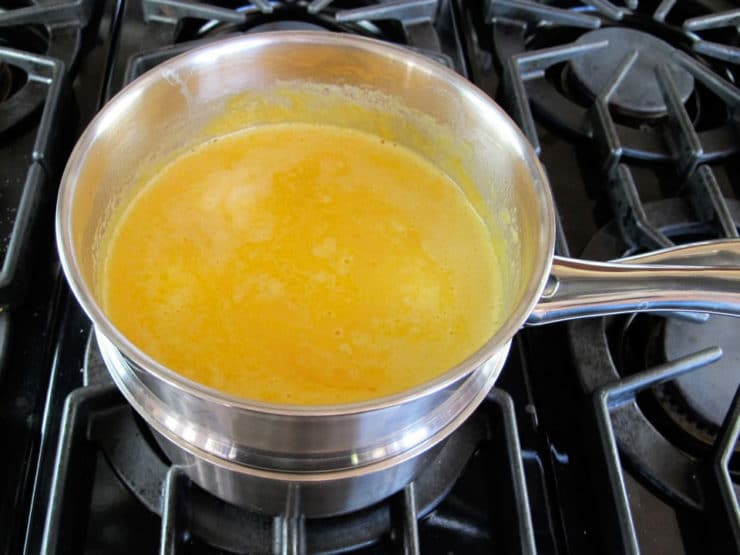 Stirring beer into melted cheese.
