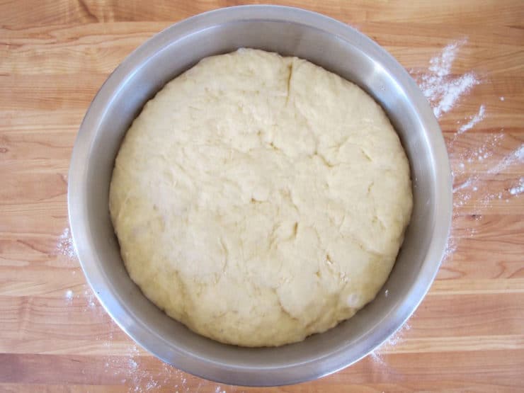 Risen challah dough in a bowl.