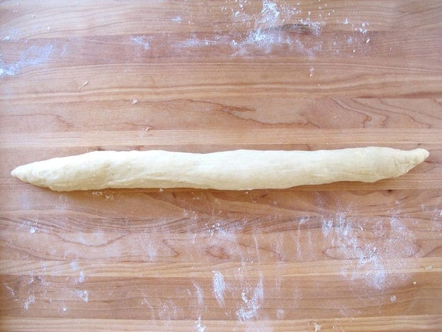 Rolling out log of challah.