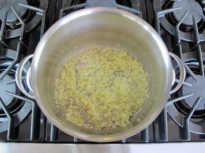 Onions sauteeing in a stockpot.