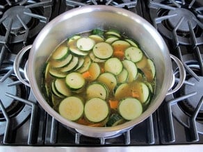 Sliced vegetables in a stockpot.