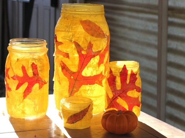 A glass jar with autumn leaves as design