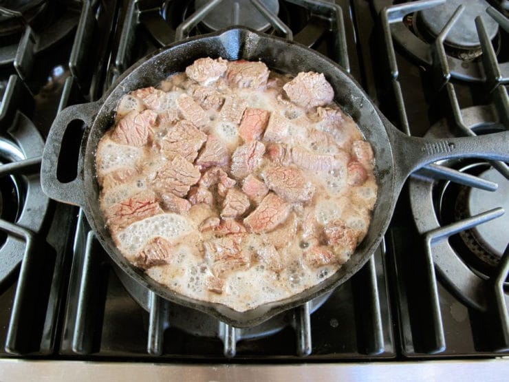 Stew meat in a skillet.