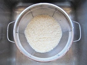 Rinsing uncooked rice.