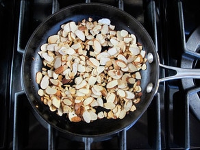 Dry toasting almonds in a skillet.