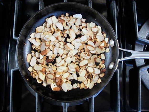 Dry toasting almonds in a skillet.