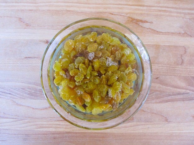 Golden raisins soaking in warm water.