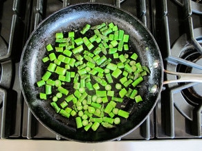 Diced asparagus in a skillet.