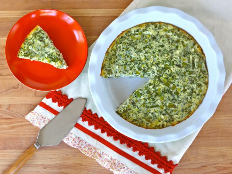 A plate with a crustless quiche featuring spinach, cheese, feta, and asparagus