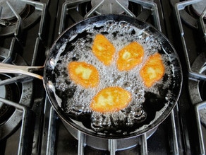 Keftes frying in a skillet.
