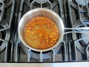 Pot of water covering almonds simmering on stovetop.