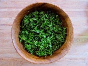 Massaging kale in a salad bowl.
