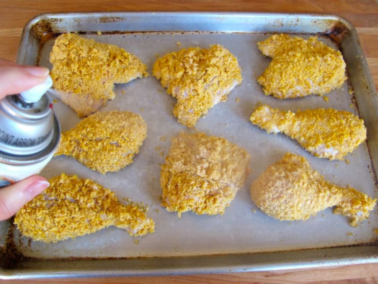 Breaded chicken parts on a baking sheet.