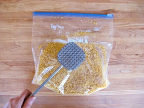 Crushing cornflakes in a zippered bag.