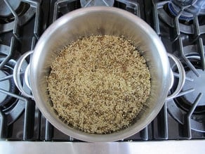 Quinoa added to lentils in stockpot.