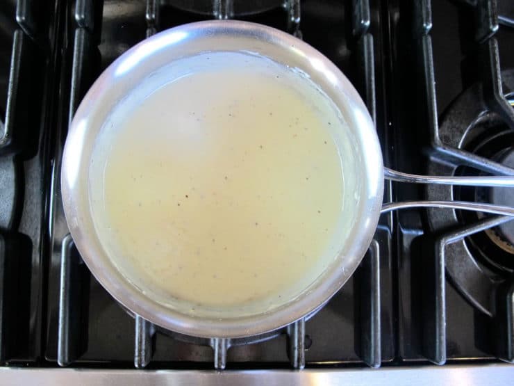 Stirring cheese into white sauce.