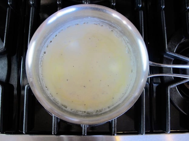 Stirring milk into a roux.