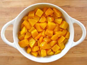 Roasted butternut squash cubes in a gratin dish.