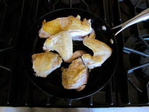 Browning chicken parts in a skillet.