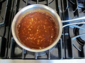 Barbecue sauce simmering in a saucepan.