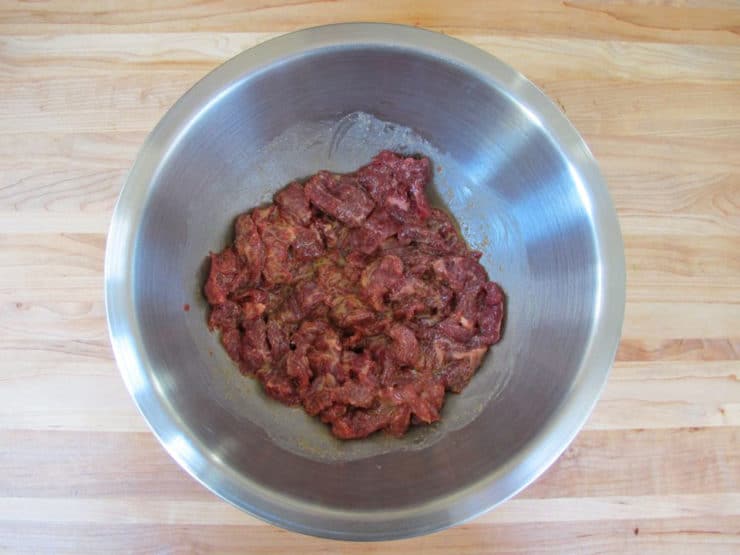 Marinade on chopped steak in a bowl.