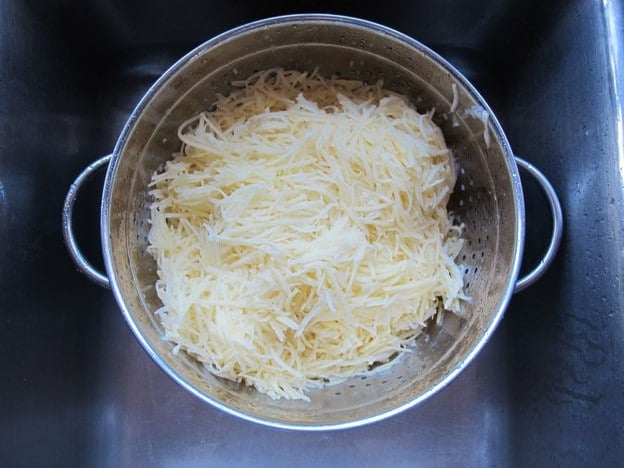 Draining shredded potatoes.