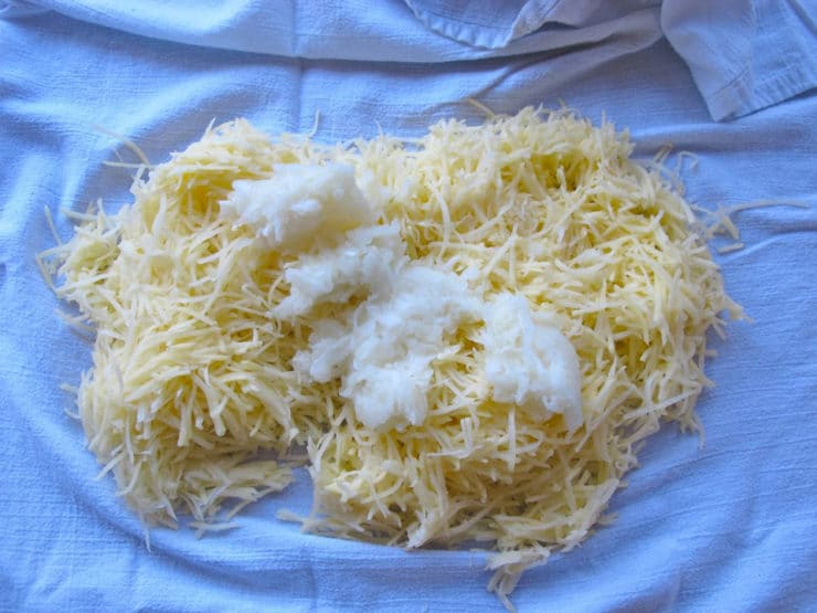 Placing shredded potatoes in a tea towel.
